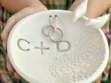 a clay plate with a lace print and monograms is a fantastic way to bring rings at your wedding, it can be DIYed