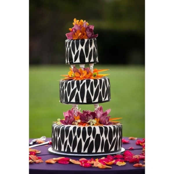 a catchy wedding cake of three parts with safari prints and bold blooms is a lovely idea with much boldness