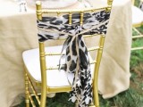 safari themed wedding reception with gold chairs with leopard covers is a cool and bold idea