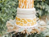 an eye-catchy safari wedding cake with a plain white, zebra and leopard print tiers, served with greenery and husks