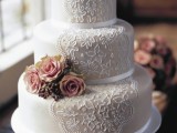 a tan wedding cake with white lace decor and pink fresh blooms is a gorgeous idea with a classic feel