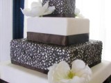 a white and usual chocolate wedding cake decorated with ribbons and two tiers covered with chocolate lace plus sugar blooms