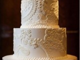 a white lace wedding cake topped with fresh white blooms on top is an elegant and stylish piece with a romantic touch