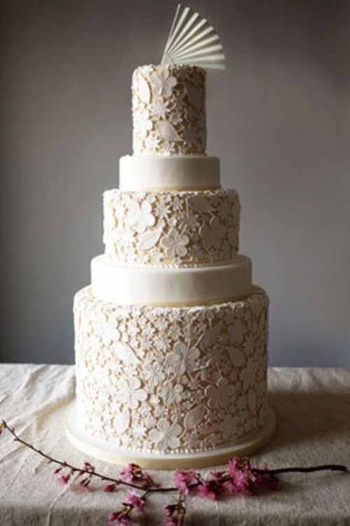 a large neutral floral lace wedding cake with some sleek tiers and a sugar fan on top is a very whimsy idea