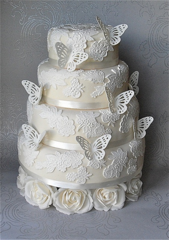 A neutral floral lace wedding cake decorated with sugar butterflies is a very chic and girlish idea