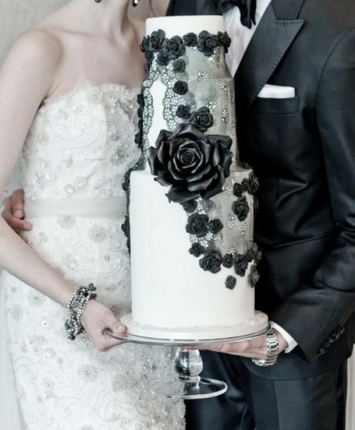 a white wedding cake with black lace and florals is a chic idea for a black and white wedding