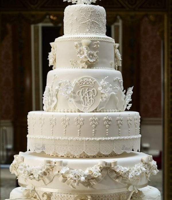 An ivory cakery masterpiece with lace, ruffle and floral decor plus beads all made of sugar