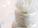 an elegant and chic white lace wedding cake topped with a single fresh white bloom is an amazing idea