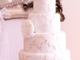 a white lace wedding cake with fresh white roses is timeless elegance with a chic feel