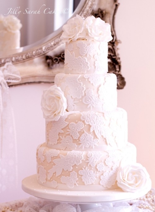 a white lace wedding cake with fresh white roses is timeless elegance with a chic feel