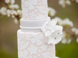 a neutral lace wedding cake with sugar blooms is a very beautiful and elegant option