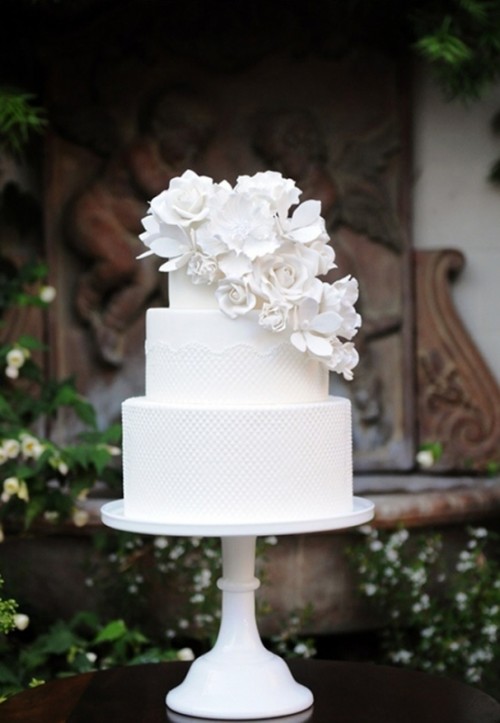 a white lace wedding cake decorated with cascading white sugar blooms is gorgeous and very unusual