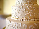 a tan wedding cake decorated with white lace and edible beads is a gorgeous idea