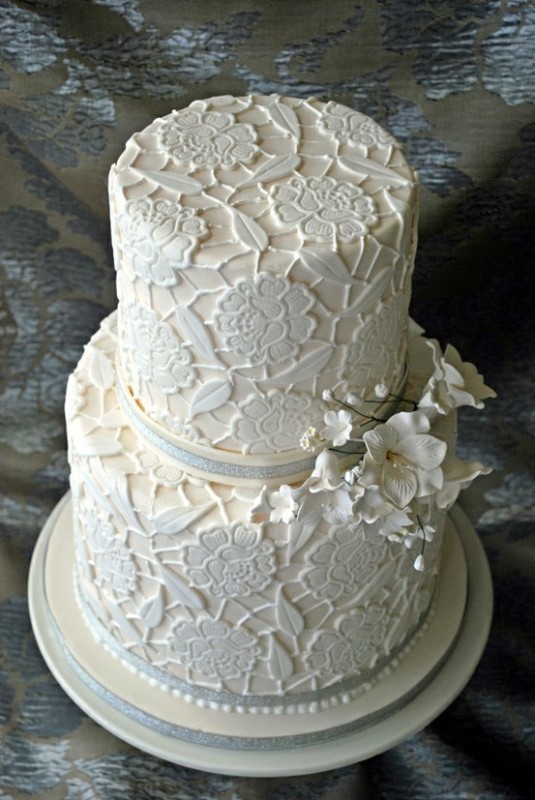 A neutral lace floral wedding cake with ribbons and sugar flowers is a beautiful and elegant idea
