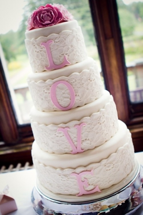 a neutral lace wedding cake with pink letters and pink sugar blooms on top is a cute idea with the main word