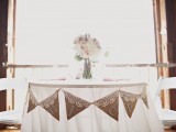 a simple cardboard and lace bunting and a tender floral centerpiece to accent the swetheart table