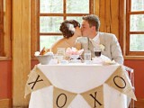 a sweetheart table covered with a lace tablecloth and a burlap bunting for a rustic touch