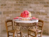 a lush pink floral centerpiece, matching napkins and floral napkin rings and candles in the center of the table