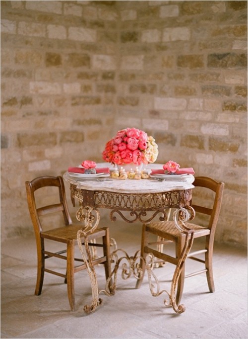 a lush pink floral centerpiece, matching napkins and floral napkin rings and candles in the center of the table