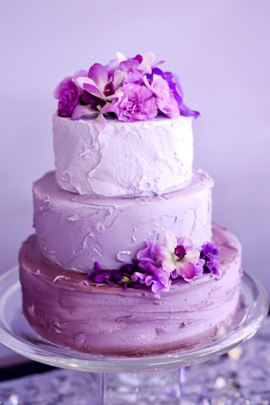 A beautiful ombre wedding cake from light pink to lilac and purple, with matching purple blooms is a gorgeous idea for a spring or summer wedding