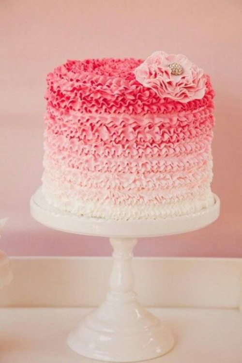 a chic vintage-inspired ombre wedding cake from fuchsia to light pink and white, with ruffles, a pink fabric bloom on top is a cool idea