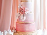an elegant and refined ombre wedding cake with light pink and brighter pink tiers, pink and blush sugar blooms is a very chic and stylish idea