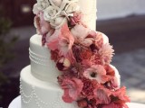 a white buttercream wedding cake with patterns and ombre blooms from white to burgundy is a lovely idea for a contrasting wedding