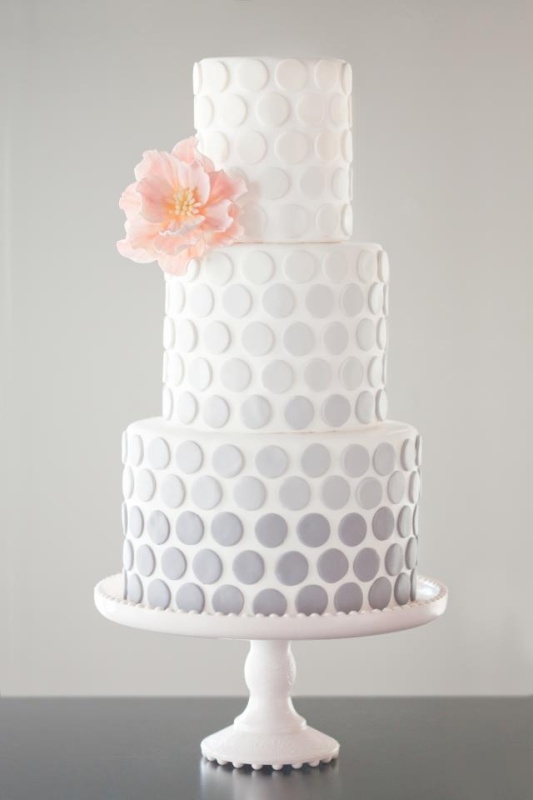 A subtle ombre grey wedding cake with a pink sugar flower is a lovely idea for a spring or summer wedding