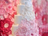 a white buttercream wedding cake with sugar blooms from white to light pink and bolder pink is a cool idea for a spring or summer wedding