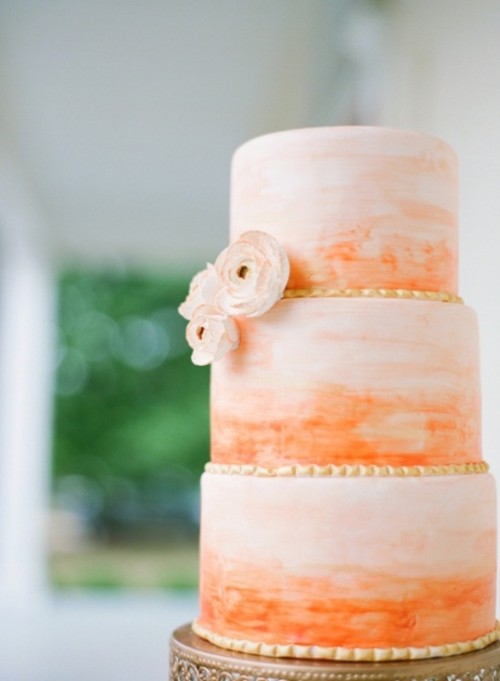 a colorful wedding cake with ombre tiers from light peachy to bold orange, with matching blooms is a lovely idea for a bright summer wedding