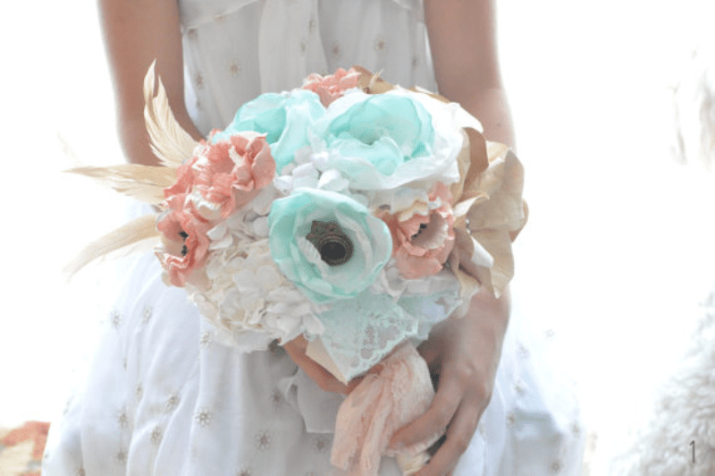 a lovely pastel wedding bouquet of mint, coral and white fabric blooms and feathers for a romantic bride