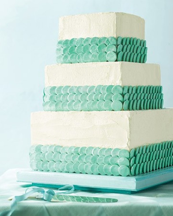 A square textural white wedding cake with mint green scales for decor looks cool, fresh and summer like