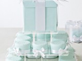 a mint box with a cake inside and mini mint-colored cakies that match a mint-colored bridal shower or wedding