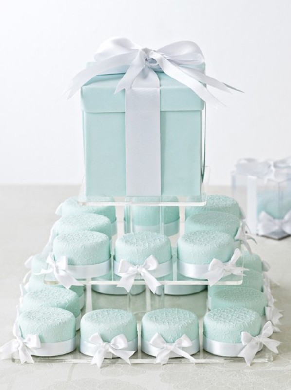 A mint box with a cake inside and mini mint colored cakies that match a mint colored bridal shower or wedding