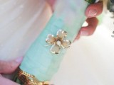 a mint ribbon bouquet wrap and a floral brooch to highlight the wedding bouquet decor