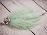 a mint wedding accessory of a feather and a vintage brooch is a cool and cute idea
