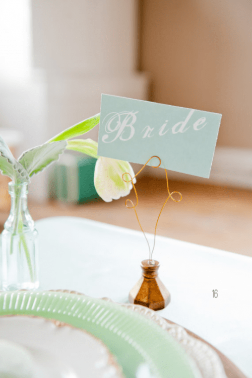 a mint seating card on a stone stand with wire is a cool idea to mark the place setting