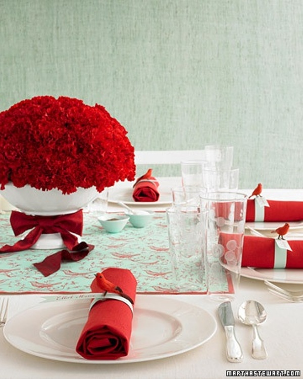 A bright mint and red wedding tablescape with red textiles, bright red blooms and a red rose centerpiece