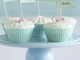 cute cupcakes with icing, edible beads and flowers in mint green liners and with fun toppers
