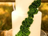 a white wedding cake decorated with emerald sugar yarn is a cool way to add the color to the dessert table