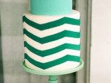 a mint and emerald and white chevron wedding cake on a mint stand for a modern wedding