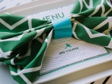 an emerald and white napkin with a geometric print and a blue bow