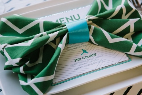 an emerald and white napkin with a geometric print and a blue bow