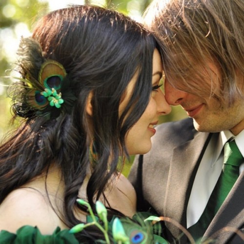 an emerald tie and a peacock feather with an emerald brooch - small accessories to add emerald to your wedding