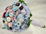 a wedding bouquet made of colorful and pastel colored buttons with leaves of paper and a neutral wrap