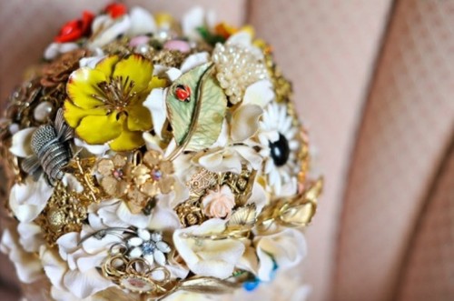 a bright and colorful brooch wedding bouquet in various colors with leaves and flowers is a refined option for a bride