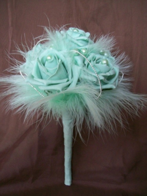 a mint green wedding bouquet of fabric blooms, pearls and feathers is a chic idea