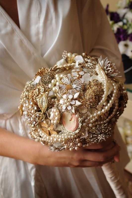 A sophisticated gold and white brooch wedding bouquet with pearls, beads and embellished flowers