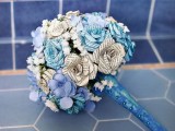 paper and fabric faux flowers in blue shades with a blue wrap with buttons is refined and chic