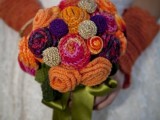 a colorful and bright knit flower wedding bouquet with green silk ribbons and matching mittens